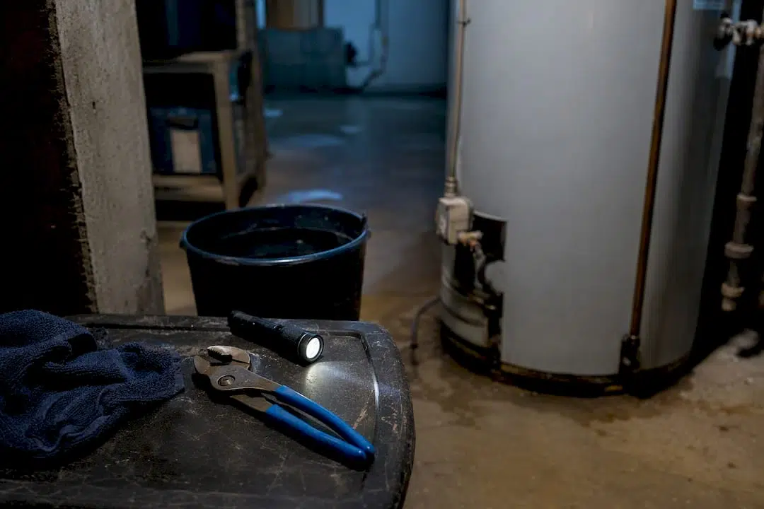 Flashlight and channel-lock pliers on shelf near water heater
