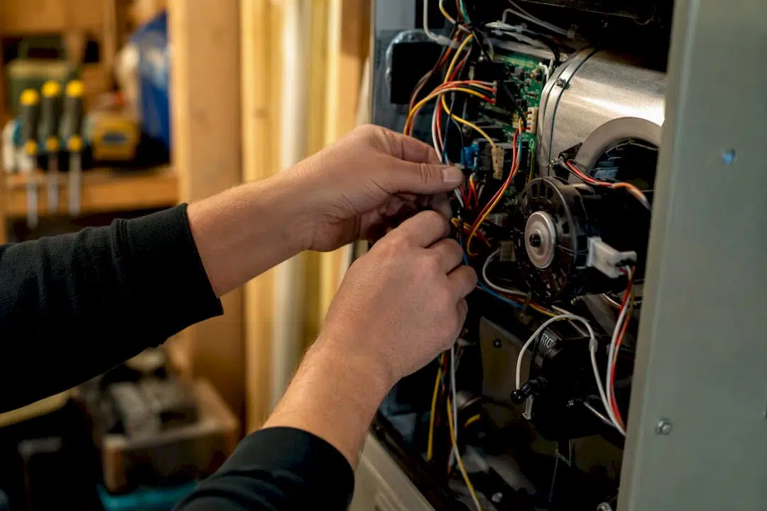 Technician hands diagnosing HVAC blower and control board