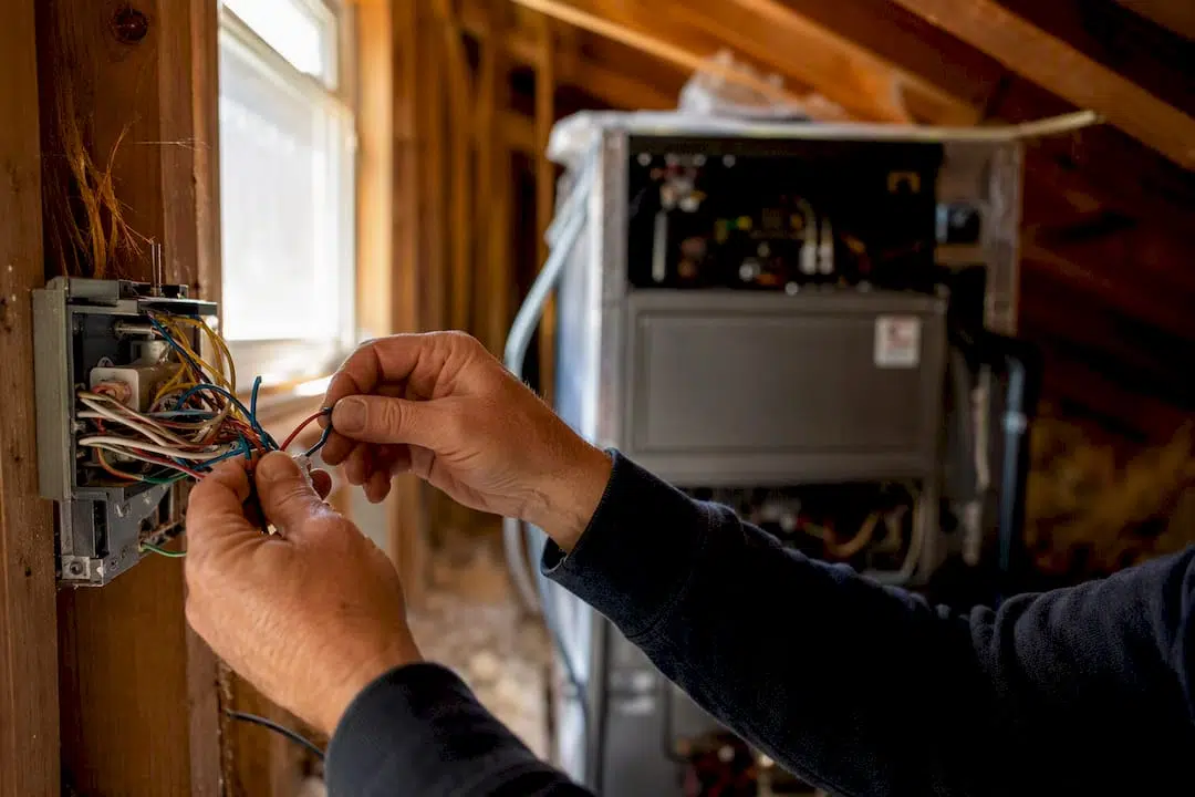 Technician wiring new thermostat unit