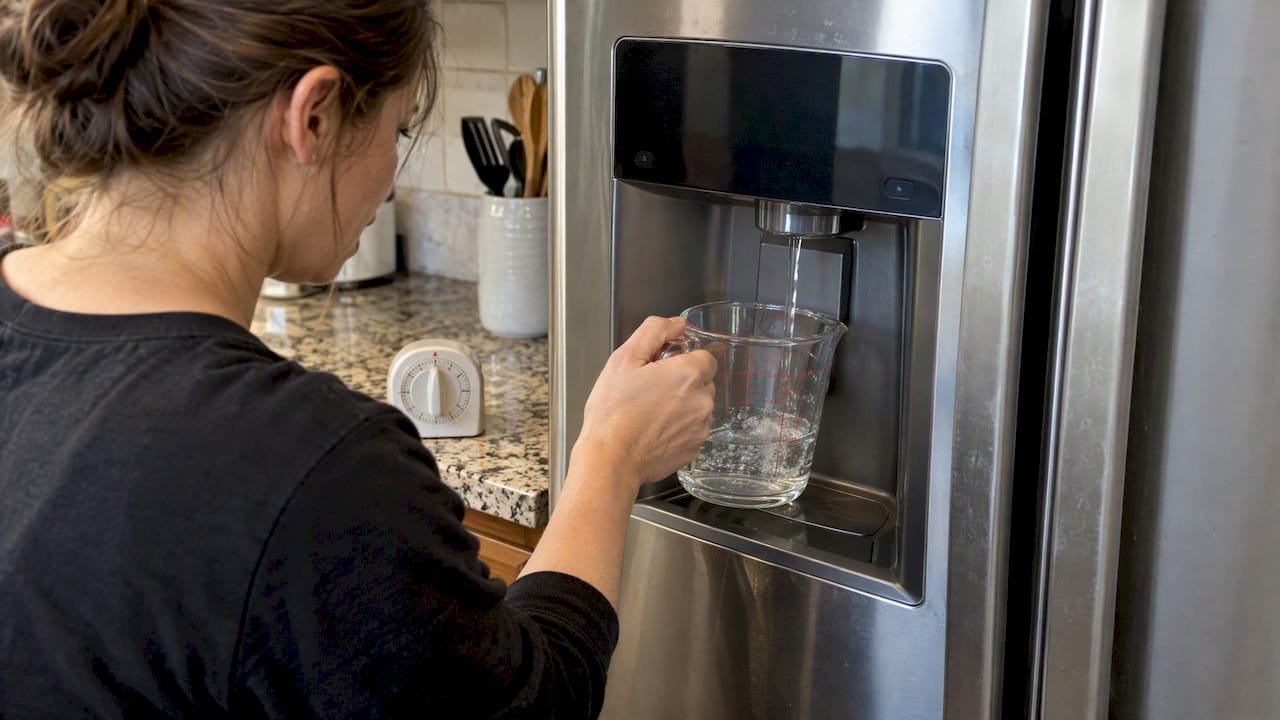 Measuring cup filling from refrigerator dispenser